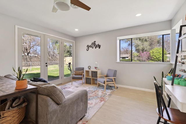 living area with plenty of natural light, french doors, light wood-style floors, and ceiling fan