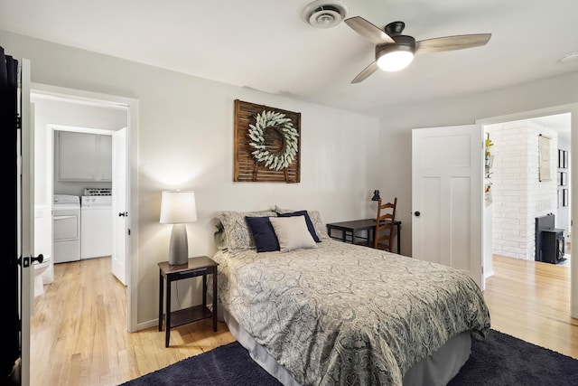 bedroom featuring washer and dryer, baseboards, visible vents, and light wood finished floors