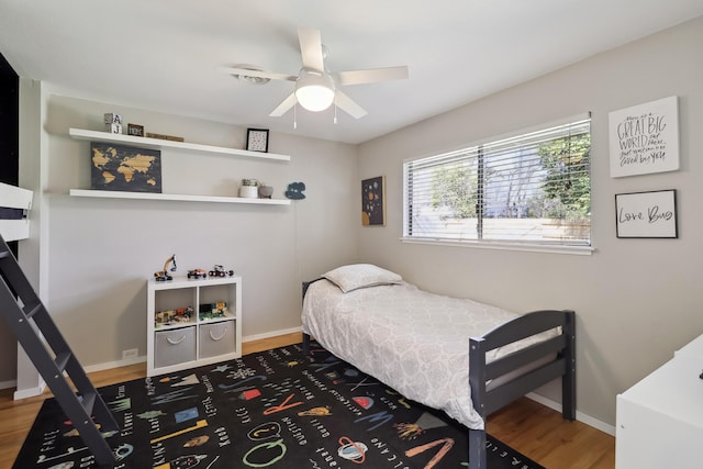 bedroom with ceiling fan, baseboards, and wood finished floors