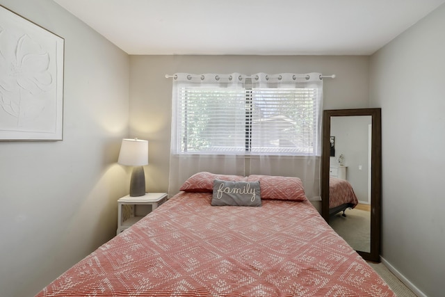 bedroom with baseboards and carpet