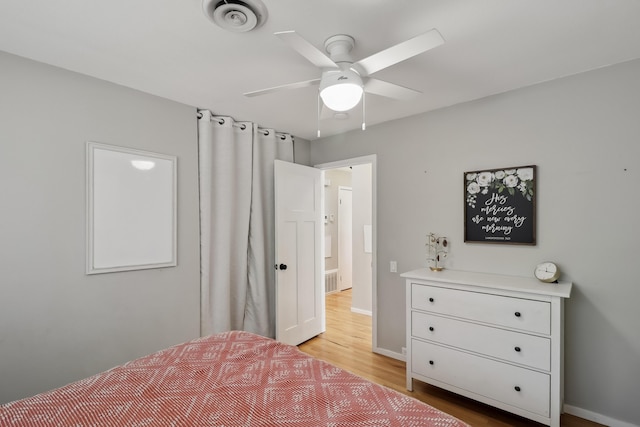 bedroom with visible vents, baseboards, light wood-style floors, and a ceiling fan