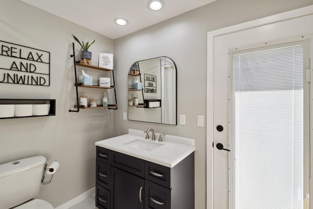 bathroom featuring recessed lighting, toilet, vanity, and baseboards