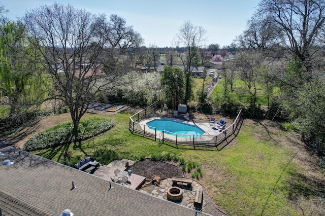 view of pool featuring a lawn, fence, an outdoor fire pit, a fenced in pool, and a patio area