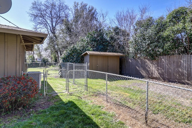 view of yard featuring a storage unit, fence, an outdoor structure, and a gate