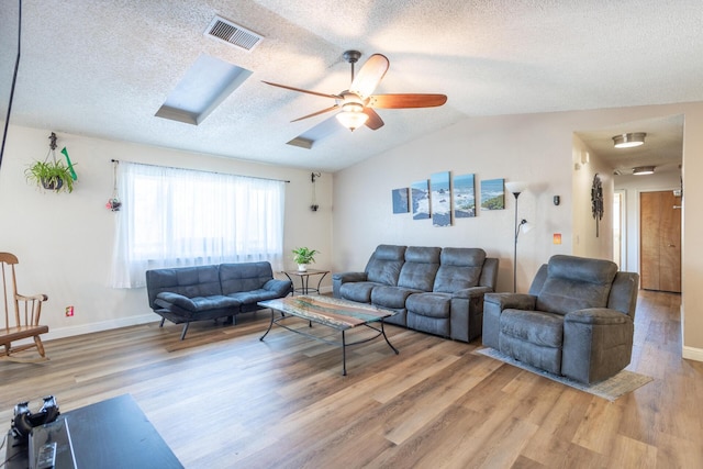 living room with visible vents, ceiling fan, light wood-type flooring, and lofted ceiling