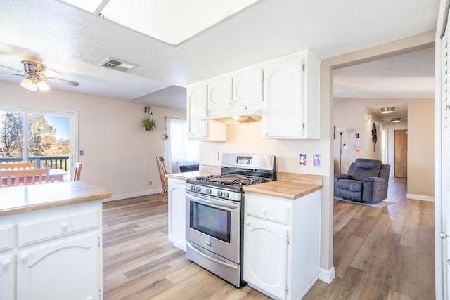 kitchen with gas stove, visible vents, plenty of natural light, under cabinet range hood, and white cabinetry