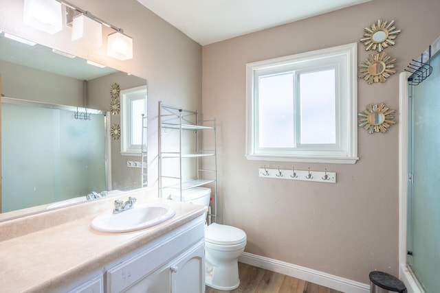 full bath featuring a shower with door, baseboards, toilet, wood finished floors, and vanity