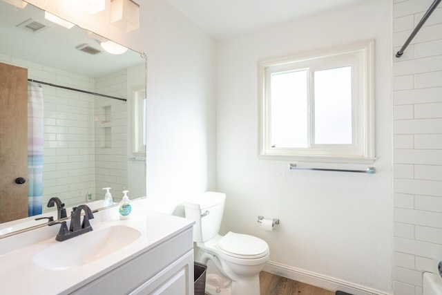 full bathroom featuring a shower with shower curtain, visible vents, toilet, and vanity