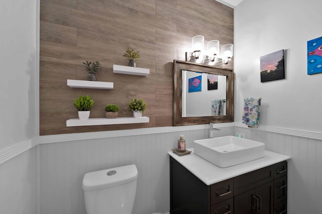 bathroom with wainscoting, vanity, and toilet