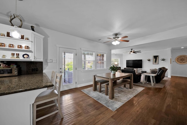 dining room featuring baseboards, dark wood-style floors, and a ceiling fan