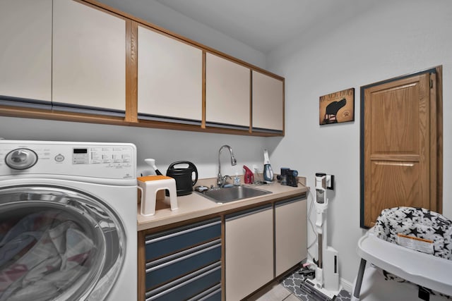 laundry area with cabinet space, washer / clothes dryer, baseboards, and a sink