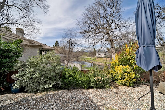 view of yard featuring fence and a water view