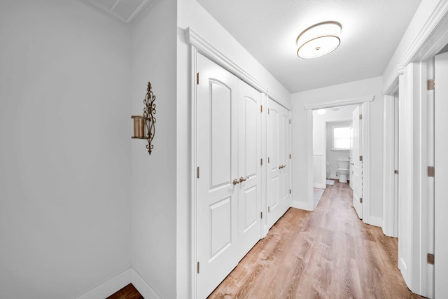 hallway with light wood-style floors and baseboards