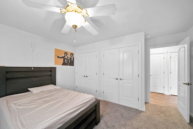 carpeted bedroom featuring two closets and ceiling fan