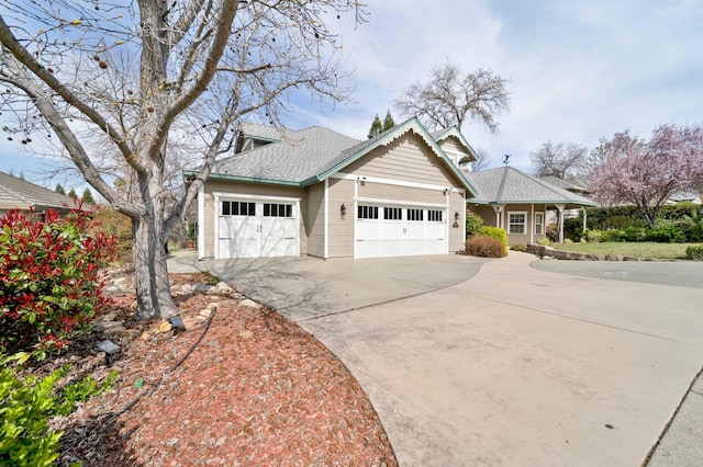 view of front facade featuring an attached garage, driveway, and roof with shingles