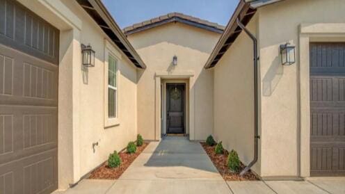 view of exterior entry with stucco siding