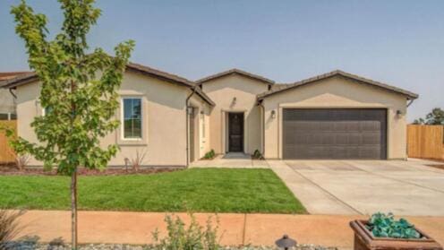 ranch-style home featuring stucco siding, a front lawn, fence, concrete driveway, and an attached garage