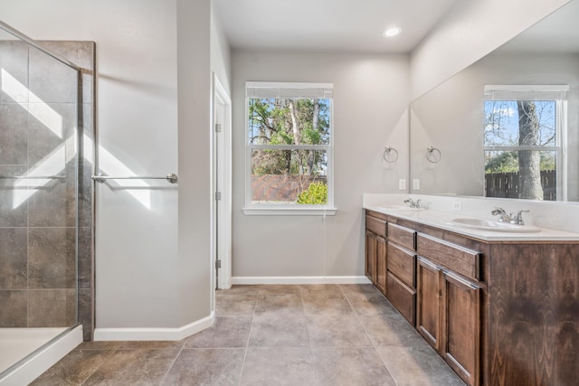 full bathroom featuring a sink, double vanity, and a shower stall