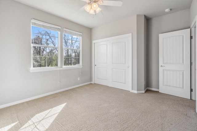 unfurnished bedroom with carpet flooring, baseboards, a closet, and ceiling fan