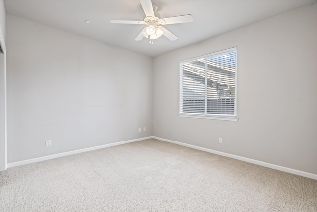 carpeted spare room with baseboards and ceiling fan