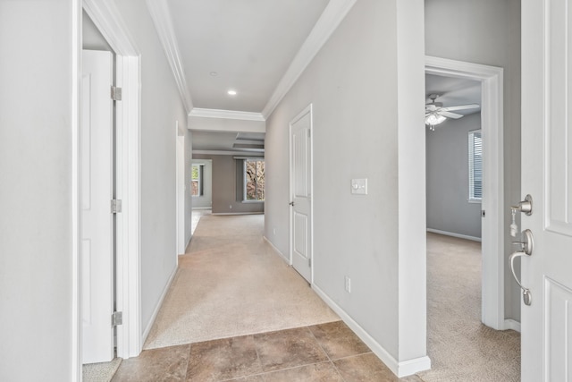 hallway featuring light colored carpet, baseboards, and ornamental molding