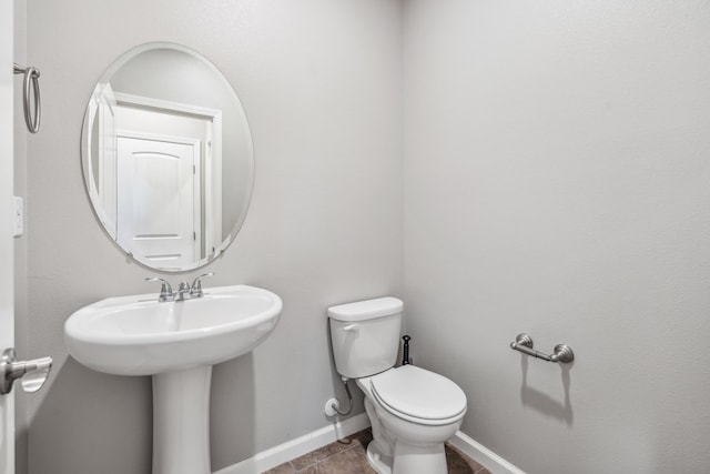 bathroom featuring baseboards and toilet