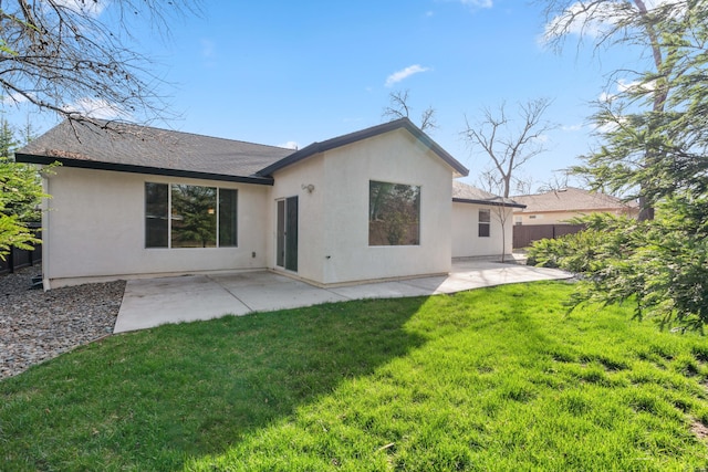 back of property with a patio, a lawn, fence, and stucco siding