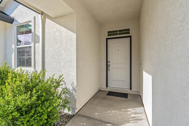 doorway to property featuring stucco siding