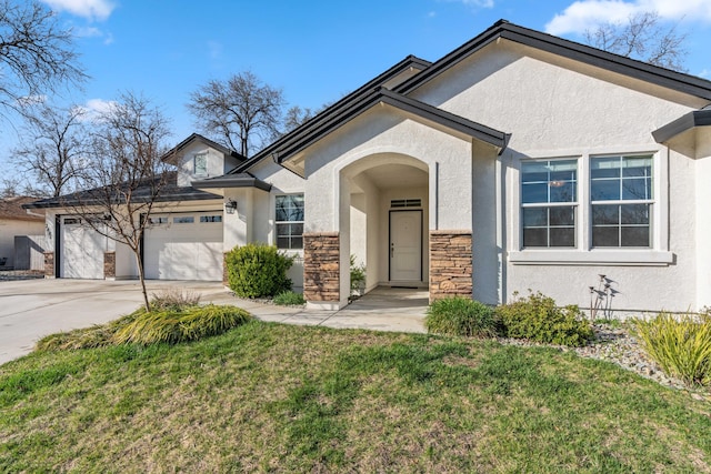 view of front of home with stucco siding, a front lawn, stone siding, concrete driveway, and a garage