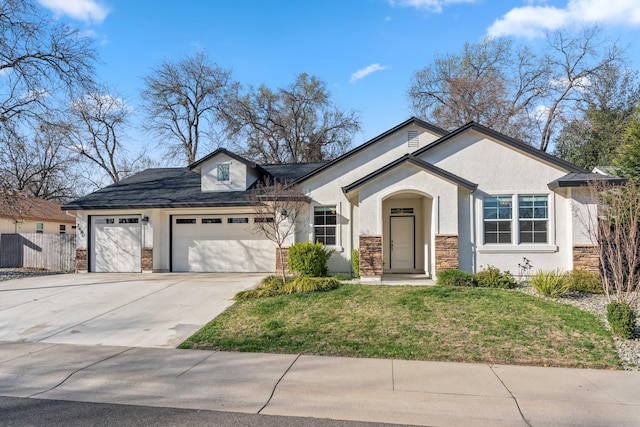 view of front facade with stucco siding, a front lawn, concrete driveway, and a garage