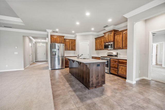 kitchen with visible vents, a center island with sink, a breakfast bar area, stainless steel appliances, and a sink