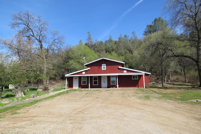 view of front facade with dirt driveway and covered porch