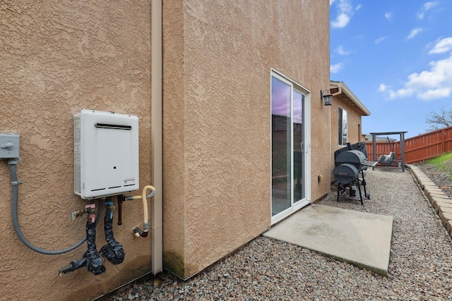 view of property exterior featuring stucco siding, a patio, and fence