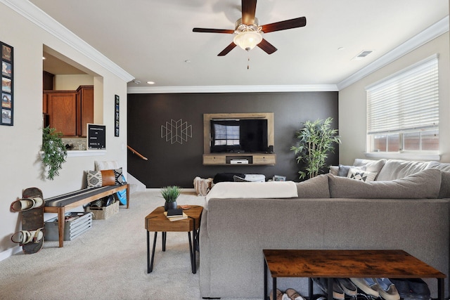 carpeted living area featuring crown molding, a ceiling fan, and visible vents