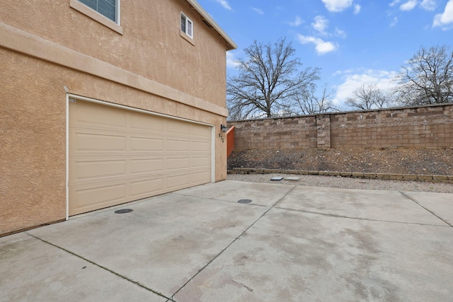 garage with fence and driveway