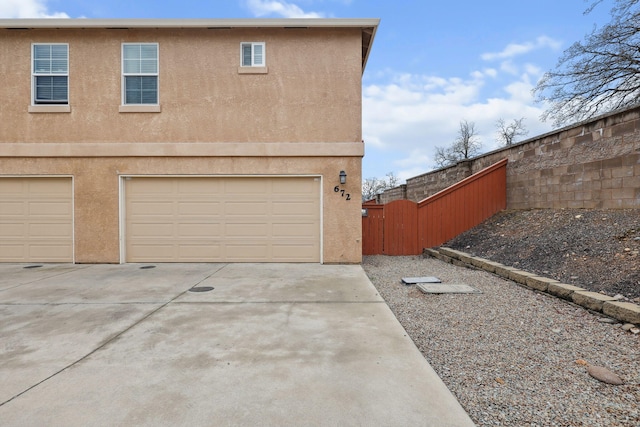 garage with driveway and fence