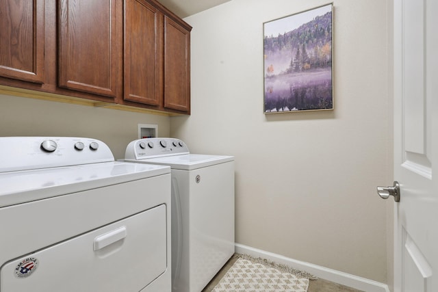 laundry area featuring baseboards, cabinet space, and washer and clothes dryer