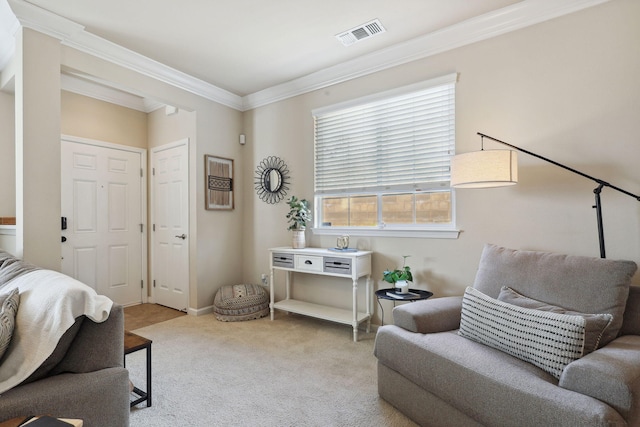 sitting room with visible vents, crown molding, and carpet floors