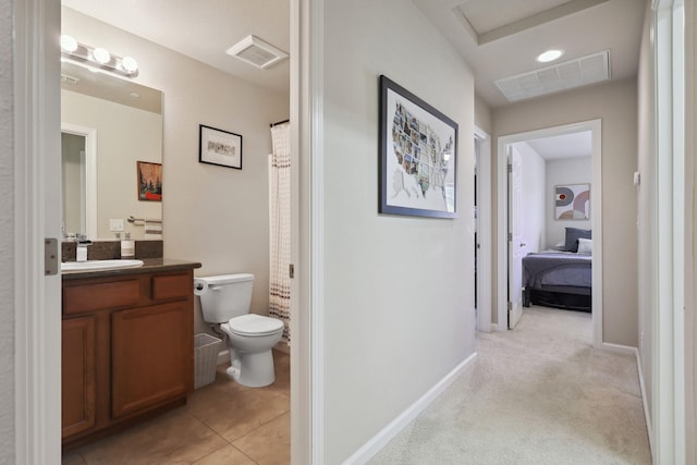 bathroom with vanity, toilet, baseboards, and visible vents