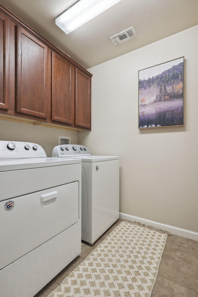 laundry area featuring baseboards, visible vents, cabinet space, and independent washer and dryer