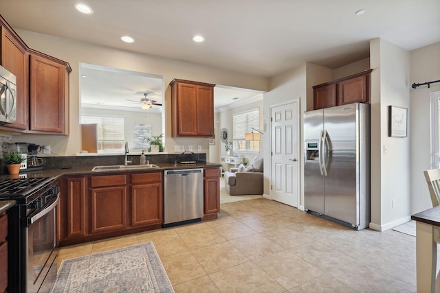 kitchen featuring ceiling fan, dark countertops, appliances with stainless steel finishes, and a sink