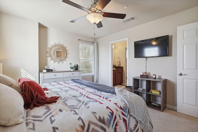 bedroom with a ceiling fan, visible vents, baseboards, light colored carpet, and connected bathroom