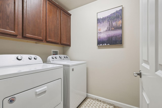 washroom featuring cabinet space, washing machine and dryer, and baseboards