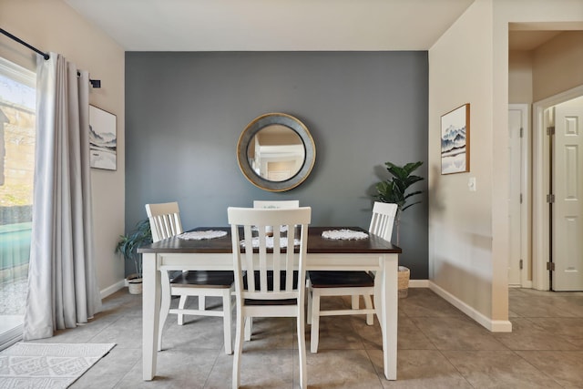 dining area featuring light tile patterned floors and baseboards