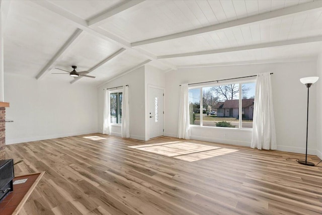 unfurnished living room with lofted ceiling with beams, wood finished floors, baseboards, and ceiling fan