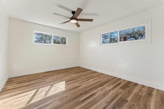 empty room featuring a ceiling fan, baseboards, and wood finished floors