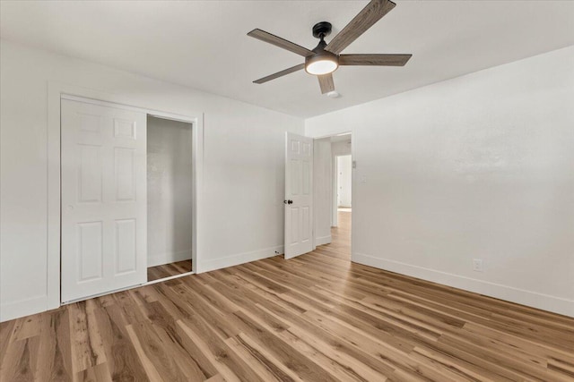 unfurnished bedroom with a closet, baseboards, light wood-style floors, and a ceiling fan