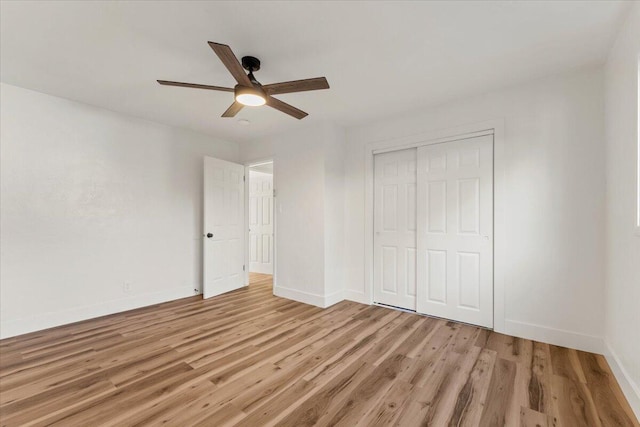 unfurnished bedroom featuring a closet, baseboards, a ceiling fan, and light wood finished floors