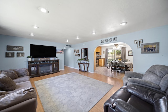 7100 Aldo Way, Anderson, CA 96007 - living room featuring arched walkways, recessed lighting, light wood-type flooring, and baseboards