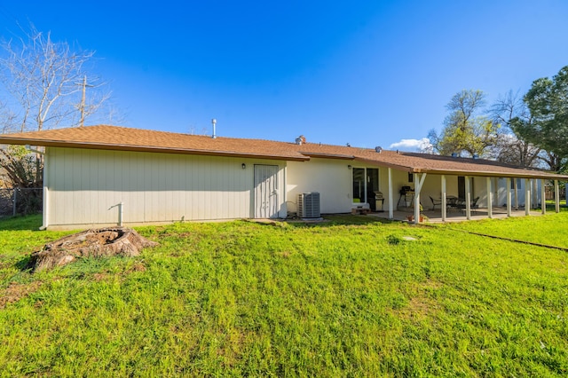 rear view of property featuring central AC unit, a lawn, and a patio